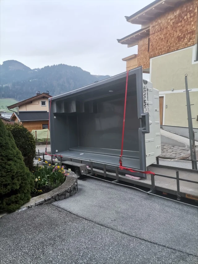 Anlieferung eines Poolbeckens auf dem Transportanhänger.