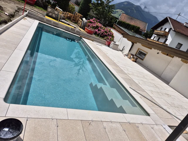 Arbeiten an den Fugen und Platten rund um den Pool.